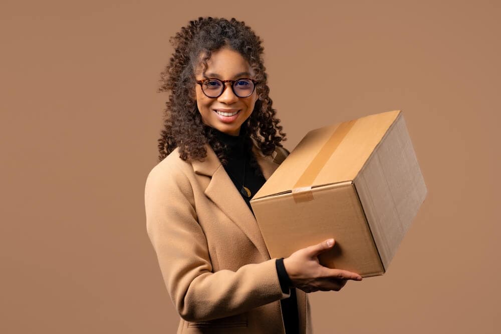 smiling woman holding a delivery box